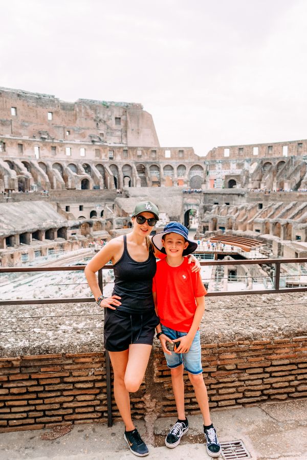 Mother and son standing inside the great Colosseum in Rome