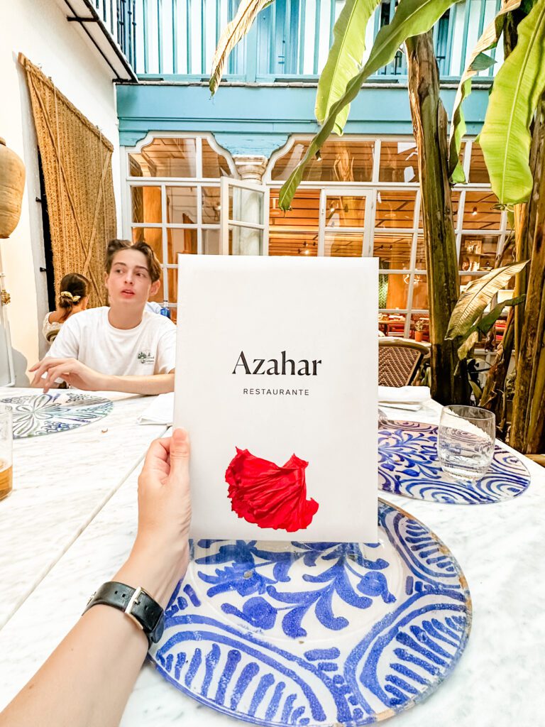 Menu for Azahar Restaurante in Seville, Spain taken in the courtyard dining area.