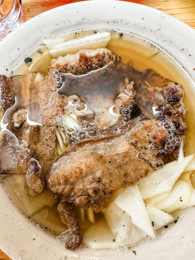 A close up of a bowl of Bun Cha soup noodles with pork belly