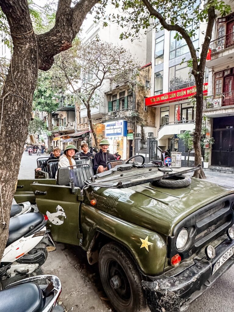 A photo of teenagers in the back of an old army Jeep ready to start the tour of Hanoi. 